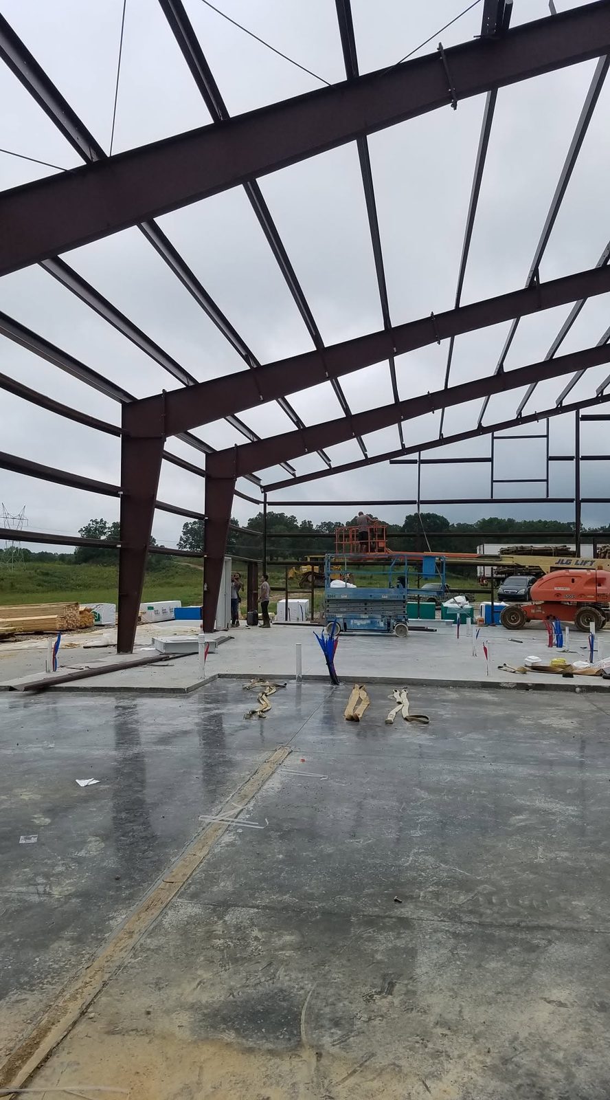 Two-tone charcoal and red clear-span shop with multiple overhead doors